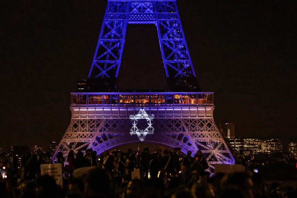 Ейфелева вежа підсвічена кольорами прапора Ізраїлю під час мітингу на підтримку Ізраїлю в Парижі, 9 жовтня 2023 року.