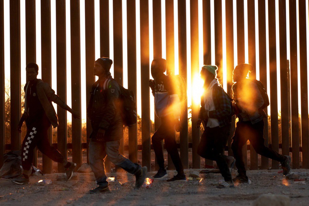 Нелегальні мігранти йдуть уздовж стіни на кордоні США в Люквіллі, штат Аризона, 12 грудня 2023 року.