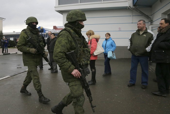 Неопознанные вооруженные люди в военной форме охраняют здание возле аэропорта в Симферополе, Крым, 28 февраля 2014.