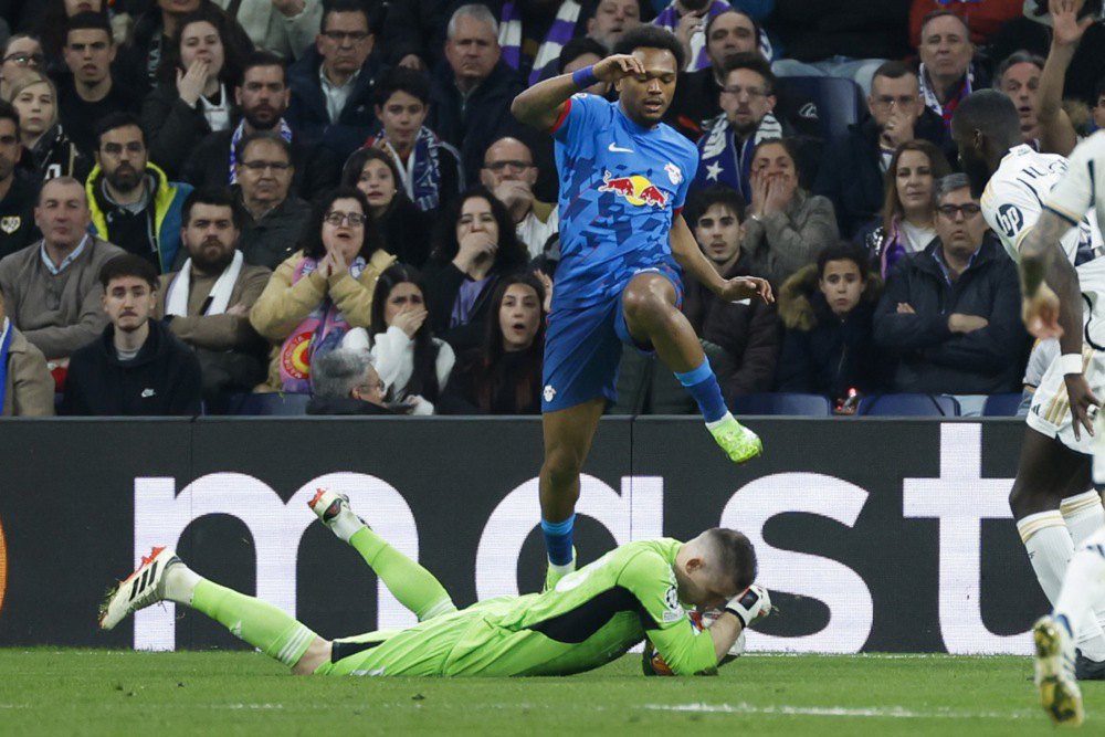 Лої Опенда, «Лейпциг», стрибає через воротаря «Реала» Андрія Луніна під час матчу в Мадриді, 6 березня 2024 року.