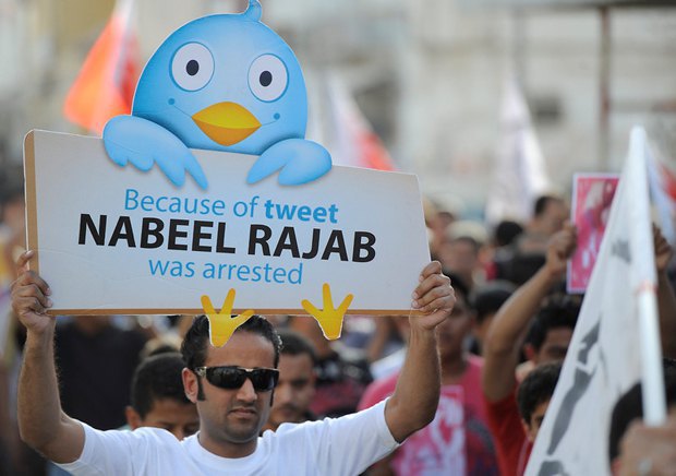 Активист держит плакат в поддержку арестованного правозащитника Набиля Раджаба за сообщения в Twitter