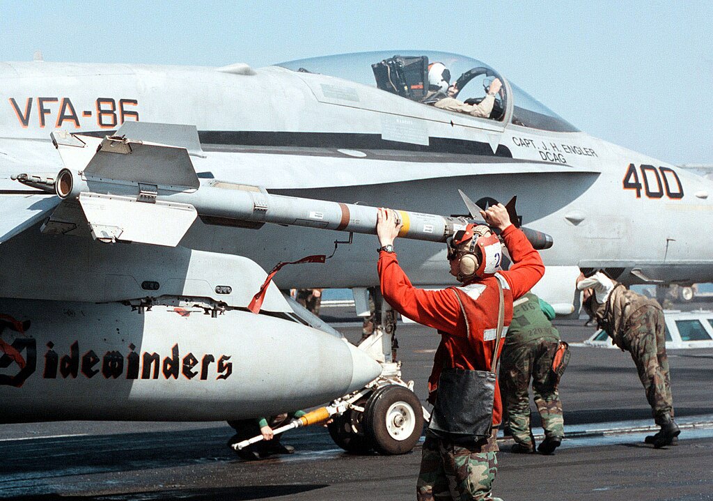  Капрал Леандер Пікенс Корпусу морської піхоти США кріпить ракету <i>AIM-9 Sidewinder</i> на американський палубний багатоцільовий винищувач <i>F/A-18C Hornet</i> перед зльотом з авіаносця <i>USS George Washington (CVN 73)</i> в Перській затоці 20 лютого 1998 р.
