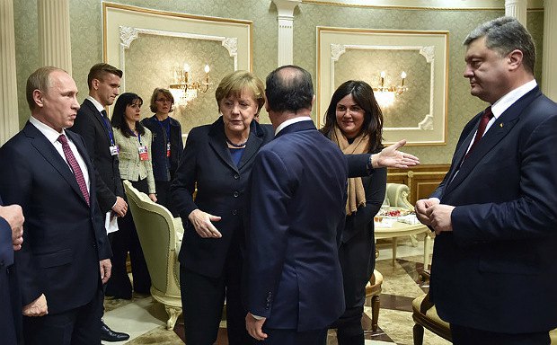 Президент России Владимир Путин, канцлер Германии Ангела Меркель, президент Франции Франсуа Олланд(спиной) и президент
Украины Петр Порошенко во время встречи в Минске, 11 февраля 2015 года.