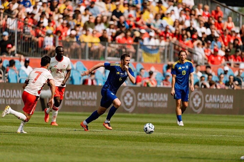 Іван Калюжний бореться за м'яч у матчі проти Канади