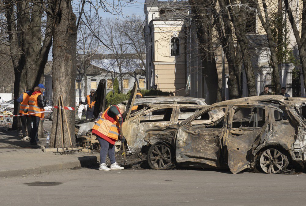 Комунальники прибирають на місці ракетного удару в Сумах.