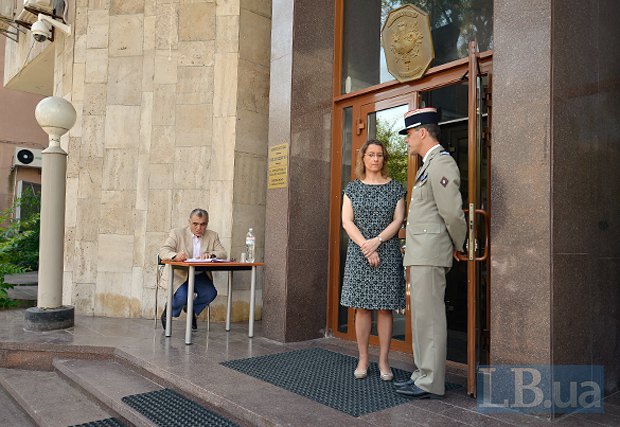 Посол Франции Изабель Дюмон общается с охранником на входе в посольство