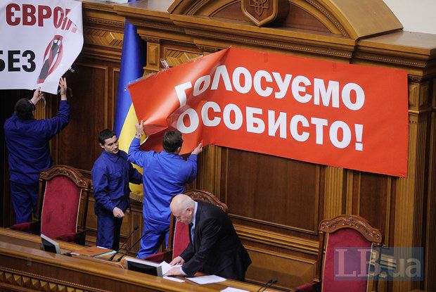 Работники Верховной Рады снимают плакаты с лозунгами оппозиции