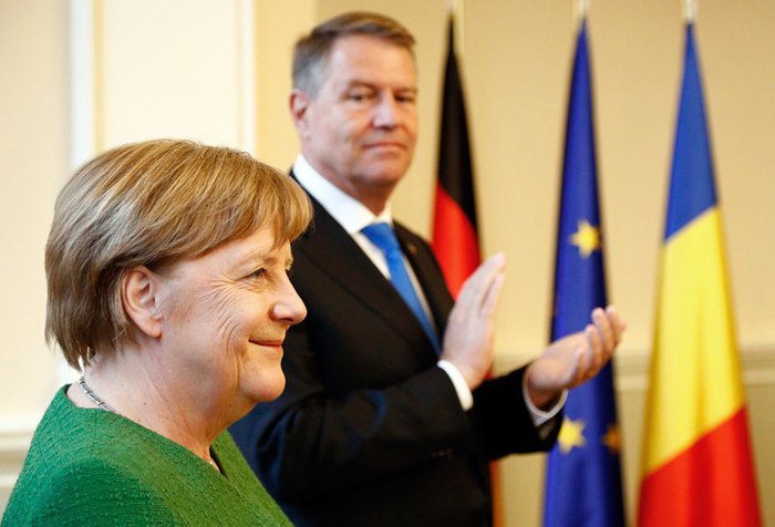 Президент Румынии Клаус Йоханнис (справа) приветствует канцлера Германии Ангелу Меркель во время неформальной
встречи лидеров Европейского союза в Сибиу, 9 мая 2019.