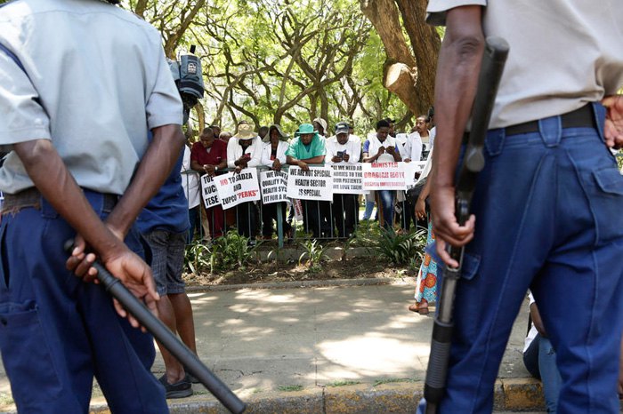 Сотрудники полиции наблюдают за акцией протеста врачей в Хараре, Зимбабве, 4 декабря 2019.