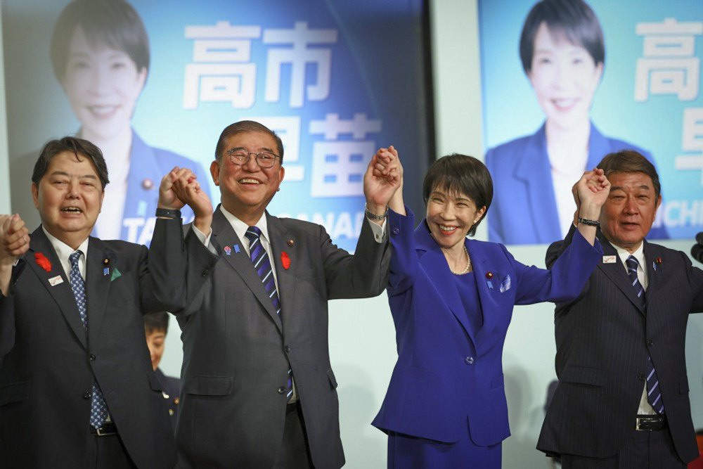 Новообрана лідерка Ліберально-демократичної партії Санае Такаїчі (праворуч), святкує разом з прем'єр-міністром Шіґеру Ішібою,
головним секретарем кабміну Японії Йосімасою Хаяші та колишнім міністром закордонних справ Тошіміцу Мотеґі свою перемогу на виборах лідера парії у Токіо, 4 жовтня 2025 року.