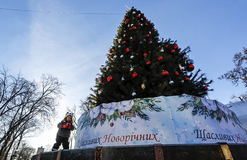 Дитина бавиться біля ялинки в центрі Києва, 13 грудня 2024 р.