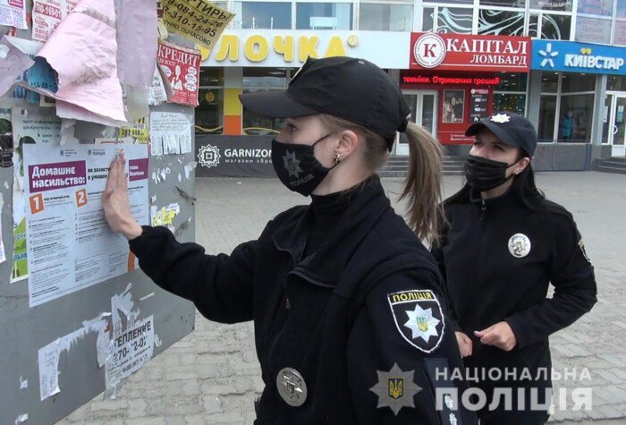 Поліцейські розклеюють плакати про запобігання домашньому насильству в Запоріжжі, квітень 2020 року.