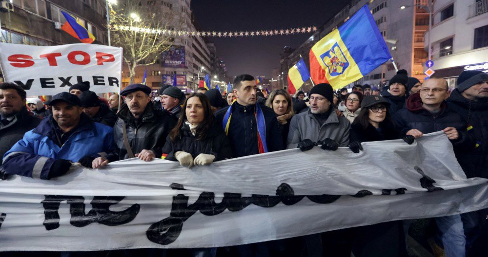 Лідер партії AUR Джордже Сіміон (у центрі) з прихильниками під час антиурядового протесту в центрі Бухареста, Румунія, 15 січня 2026 р.