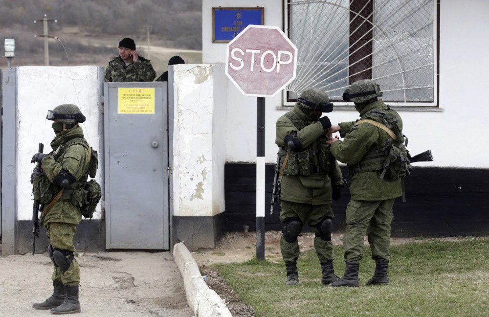 Російські загарбники, так звані «зелені чоловічки» - озброєні чоловіки у військовій формі без пізнавальних
знаків, біля української військової частини в селі Перевальне під Сімферополем, 19 березня 2014 року.
