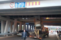 У Києві на Лівобережній навантажувач застряг під мостом (оновлено)