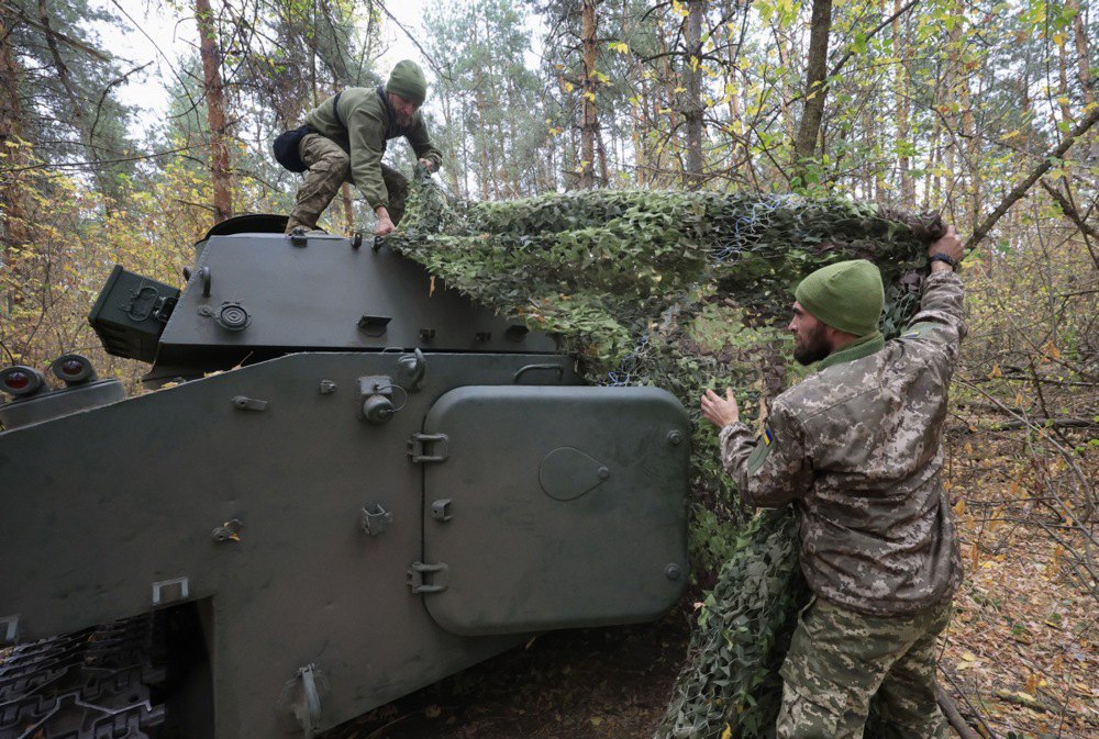 Військовослужбовці 154 окремої механізованої бригади прикривають маскувальною сіткою САУ 2С1 «Гвоздика» на передовій у Харківській області, 09 жовтня 2024 р.