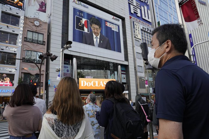 Люди смотрят прямую трансляцию пресс-конференции премьер-министра Японии Синдзо Абэ, на которой он объявил о своей отставке ,
Токио, 28 августа.