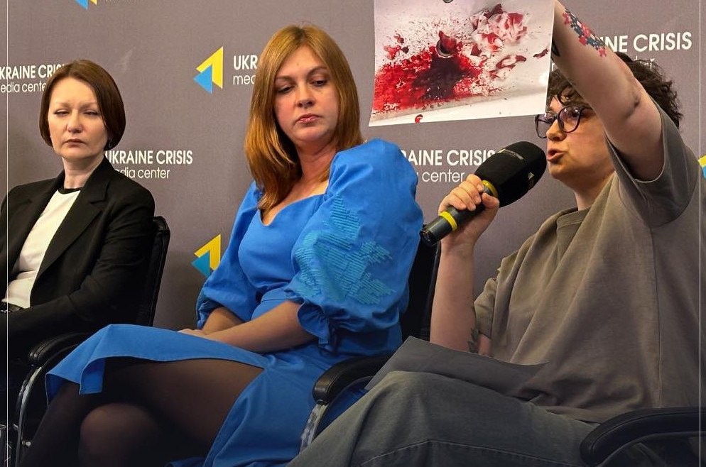 Ніна Астафорова-Яценко демострує фото під час брифінгу