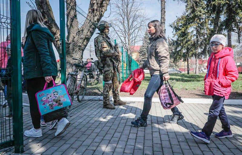 Діти та батьки йдуть зі шкільного подвір’я в окупованій Волновасі, 11 квітня 2022 року.