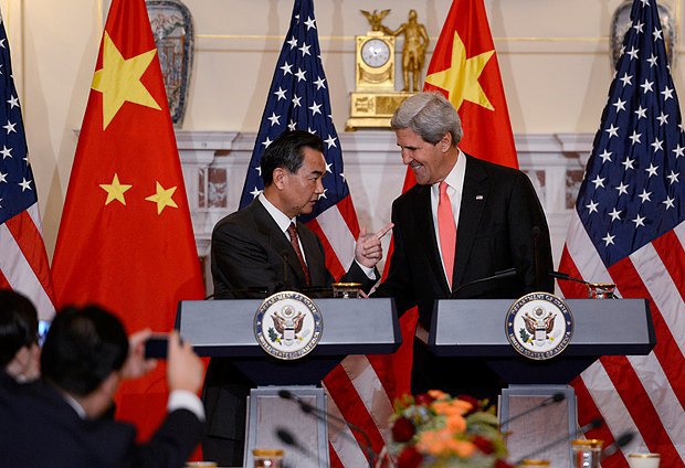 Госсекретарь США Джон Керри обменивается рукопожатием с министром иностранных дел Китая Ван И 