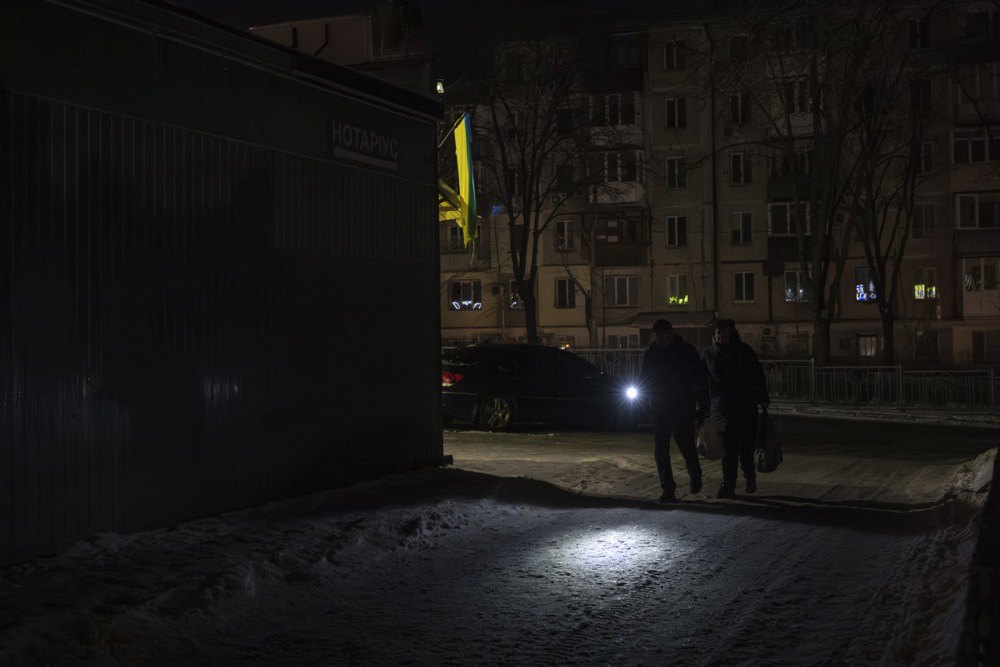 Перехожі з ліхтарем під час відключення електроенергії в Києві, 20 січня 2026 р