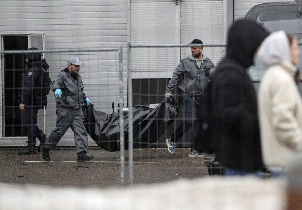 Медики виносять тіла жертв з Крокус Сіті Хол після теракту в Красногорську, 23 березня 2024 року.