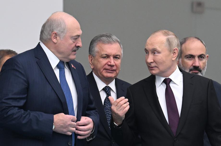 Президент РФ Володимир Путін розмовляє з президентом Білорусі Олександром Лукашенком (посередині президент Узбекистану Шавкат Мірзійоєв ) на полях саміту в Астані, 14 жовтня 2022.