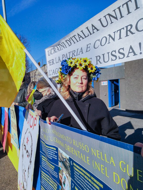 Маніфестантка на тлі гасла 'Українці Італії об'єднані проти російської агресії'