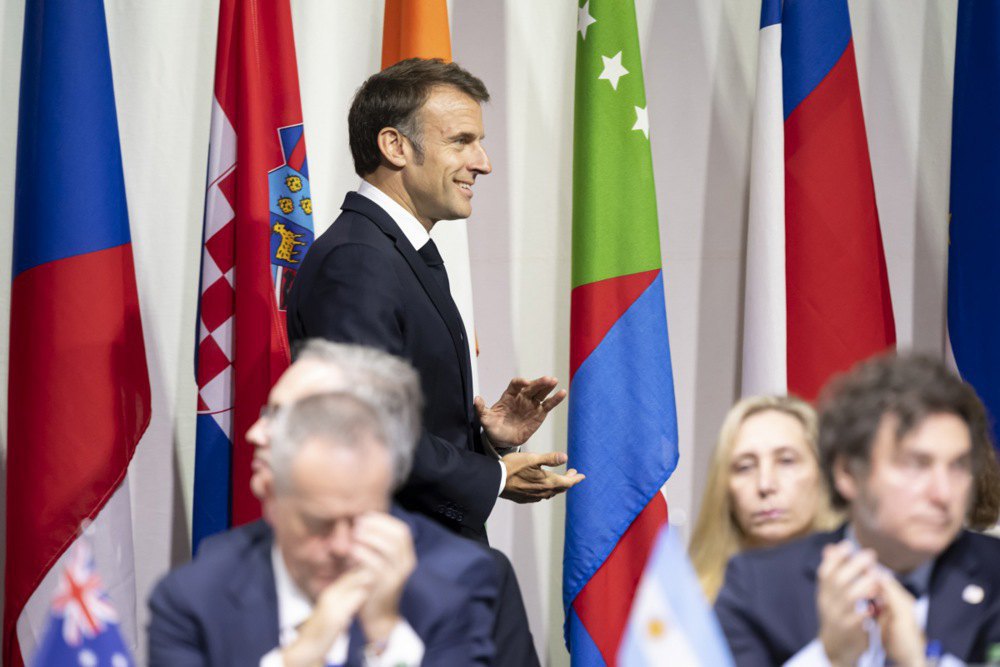Президент Франції Еммануель Макрон аплодує під час відкриття пленарного засідання Саміту миру