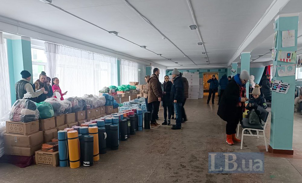 Голова РДА Максим Бахматов з громадою району розвантажує гуманітарну допомогу в опорній школі на Троєщині