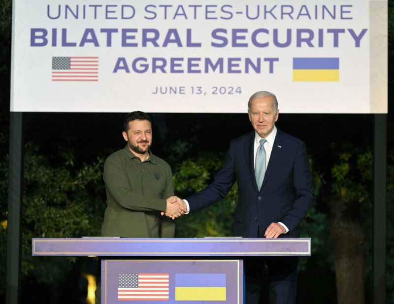 Президент США Джо Байден і президент України Володимир Зеленський підписують безпекову угоду після двосторонньої зустрічі на полях саміту <i>G7</i> в Італії, 13 червня 2024 року.
