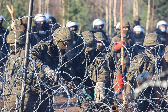 Польские военнослужащие укрепляют линию границы колючей проволокой на белорусско-польской границе в Гродненской области 9 ноября 2021 года