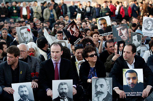 Армяне и турки держат фотографии жертв геноцида, отмечая его 98-ю годовщину в Стамбуле, в апреле 2013
