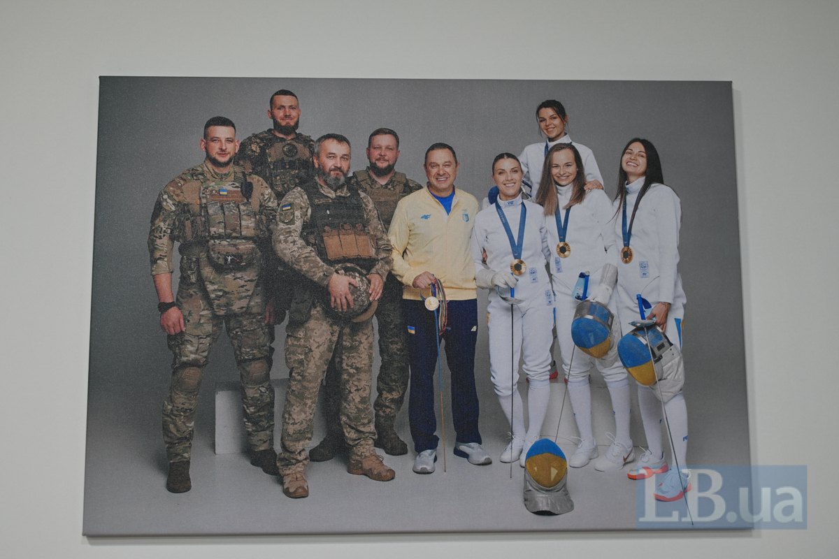 Світлина в кабінеті Вадима Гутцайта. Він стоїть разом з українськими захисниками й командою українських олімпійських чемпіонок з
фехтування 