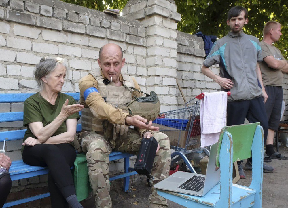 Військовослужбовець ЗСУ спілкується з мешканцями в центрі міста Суджа, 21 серпня 2024 р.