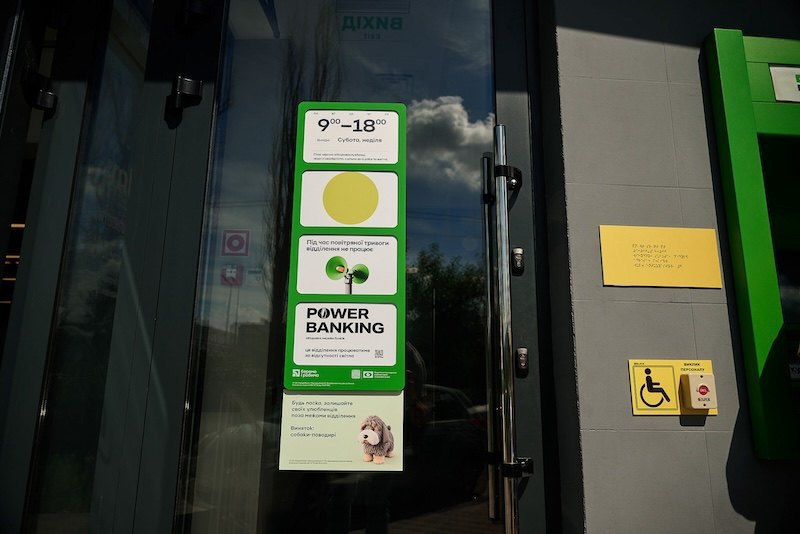 Кнопка виклику персоналу та табличка шрифтом Брайля на вході у віддління