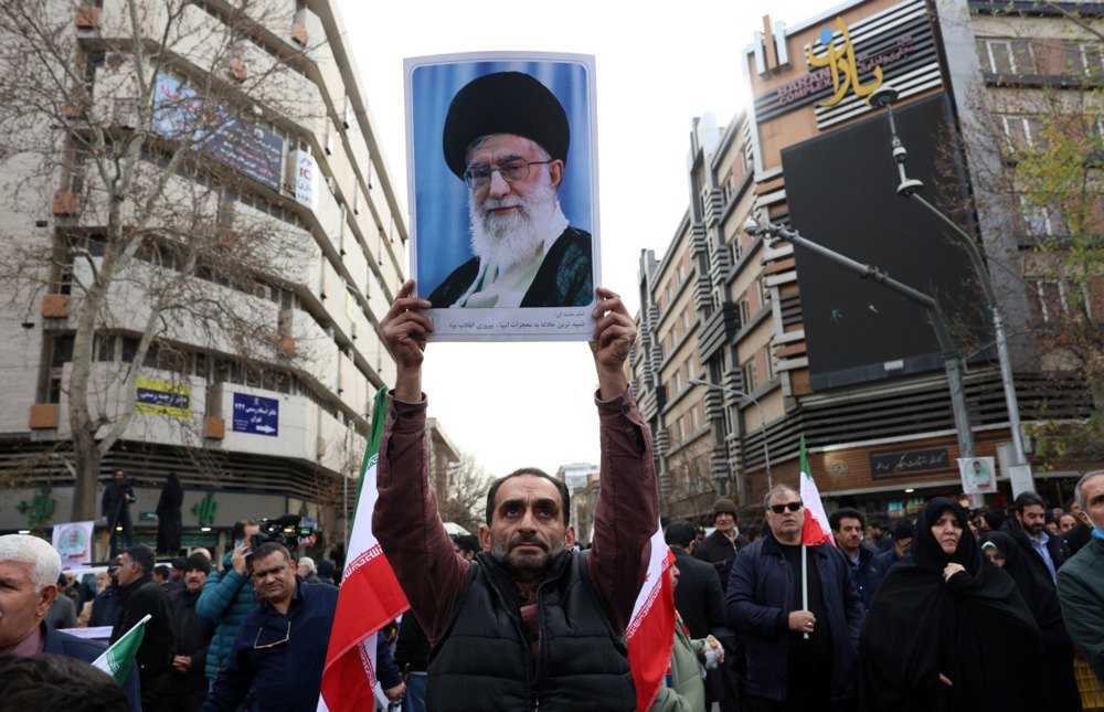 Чоловік тримає портрет Верховного лідера Ірану аятоли Алі Хаменеї під час похоронної церемонії за співробітниками служб безпеки, загиблими під час антиурядових протестів, Тегеран, 14 січня 2026 року.