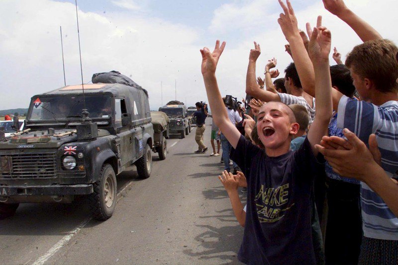 Етнічні албанці вітають британських солдатів у складі міжнародних миротворчих сил НАТО в Косові (KFOR), які проїжджають через Штімле, Косово, 12 червня 1999 року.