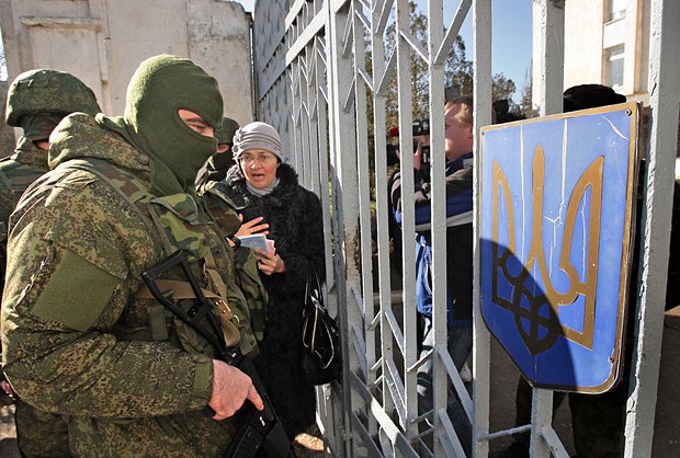 Украина более 20 лет тратила деньги на крымских военных, и только часть из них осталась верна присяге. На фото российский
военный у ворот украинской военной части в Феодосии