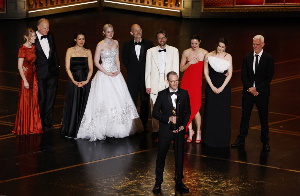 Датсько-норвезький режисер Йоахім Трієр (у центрі) на сцені разом з акторами та знімальною групою після вручення отримання премії «Оскар» за найкращий міжнародний художній фільм за фільм «Сентиментальна цінність» під час церемонії вручення премії