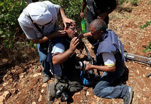 Фотографы помогают раненому товарищу. Палестина