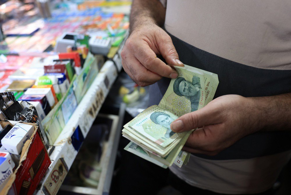 Іранський крамар рахує виторг у своєму кіоску в Тегерані, 4 серпня 2025 р.