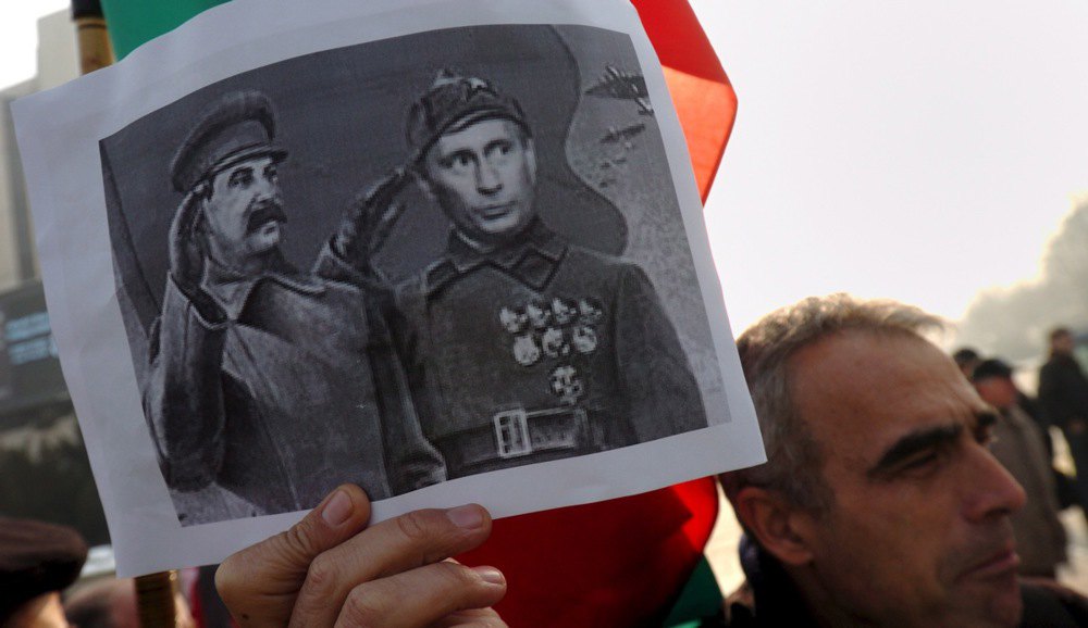  Чоловік тримає плакат із зображенням Путіна й Сталіна під час візиту російського президента Володимира Путіна до Болгарії в центрі Софії, 18 січня 2008 року.