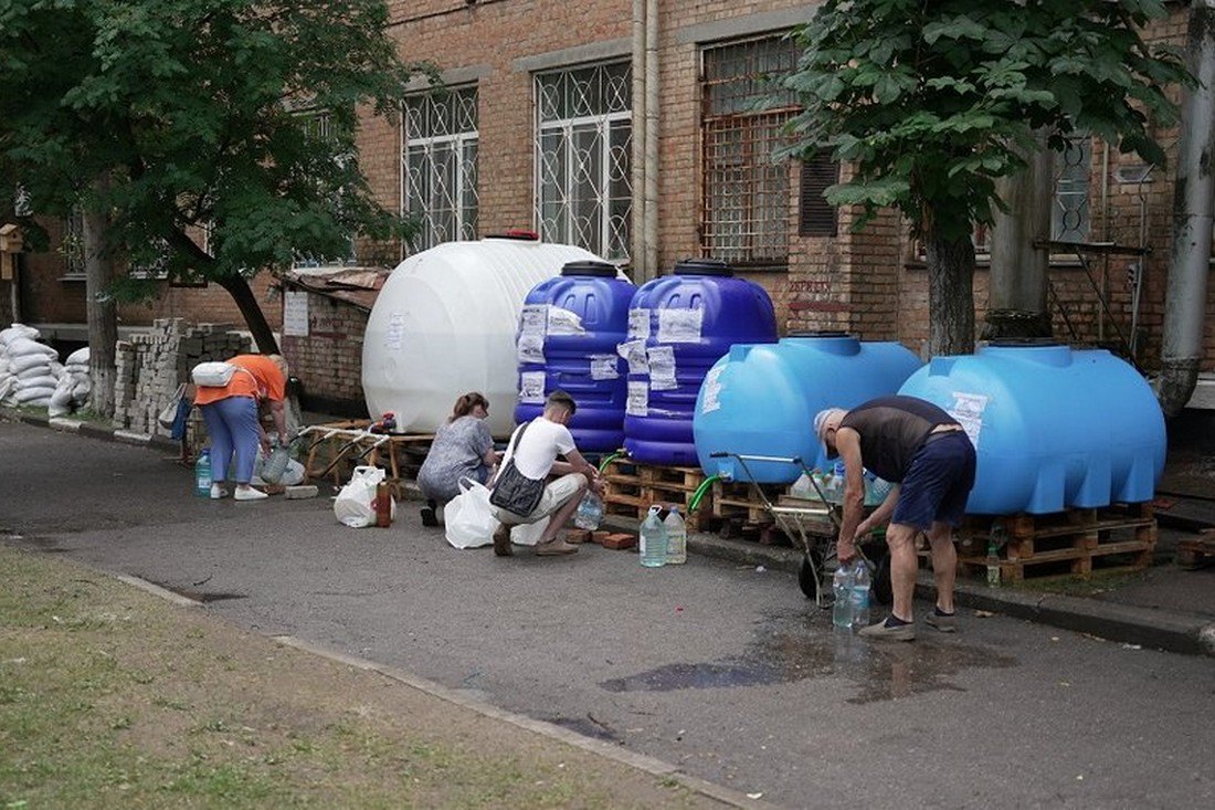 У Нікополі на Дніпропетровщині після руйнування Каховської ГЕС місцеві жителі набирають воду в пунктах роздачі.