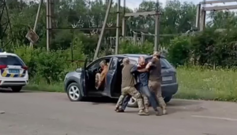 Працівники ТЦК та СП застосовують фізичну силу, щоб затримати чоловіка.