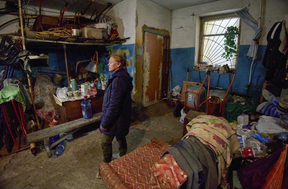 Жінка стоїть посеред підвалу свого будинку, де вона разом з сусідами ховається від обстрілів, Куп’янськ