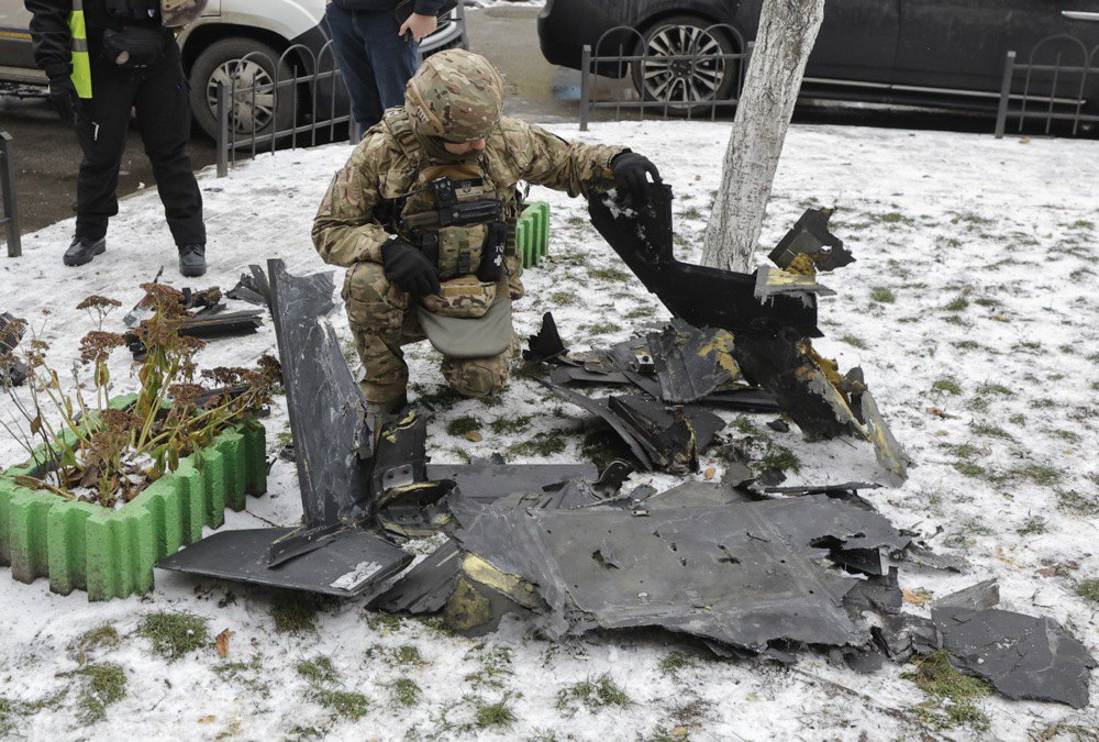 Експерт оглядає уламки російського ударного безпілотника на місці удару по багатоповерхівці в Києві, 27 грудня 2025 р.