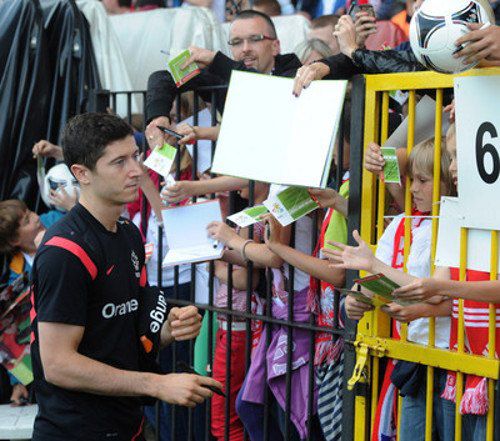 Нападающей сборной Польши Роберт Левандовски раздает автографы после открытой тренировки