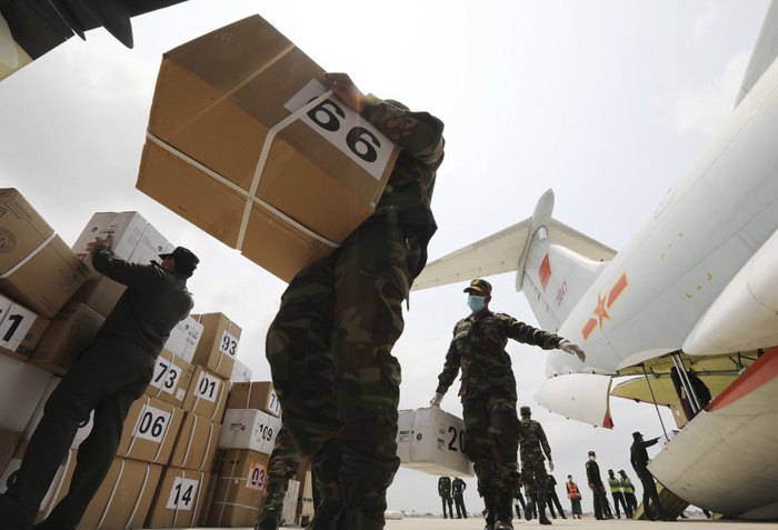 Солдаты выгружают медикаменты с китайского самолета в международном аэропорту в Пномпене, Камбоджа, 1 апреля 2020.