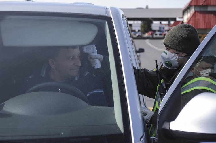 Український прикордонник перевіряє температуру тіла водія на українсько-польському кордоні